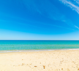 Fototapeta na wymiar Turquoise water, white sand and blue sky in Cala Sinzias