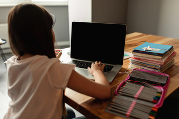 Online learning. Girl with a laptop, e-learning at home. Schoolgirl study with a video call. Distance education