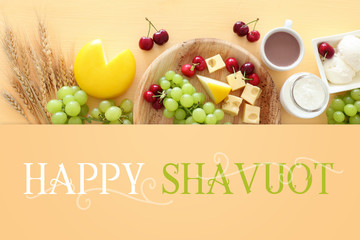 Top view photo of dairy products over pastel yellow background. Symbols of jewish holiday - Shavuot