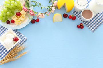 Top view photo of dairy products over pastel blue background. Symbols of jewish holiday - Shavuot