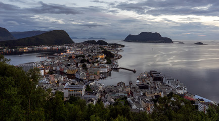 Panorama over aalseund city from the viewpoint Aksla during blue hour, city lights light up in the city.