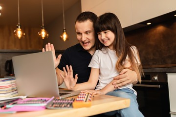 Online learning. Schoolgirl and her father washed their hands with a sanitizer before starting an online lesson and showing their hands to a teacher