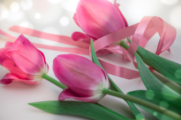 A bouquet of pink tulips for the holiday bandaged with a pink ribbon.