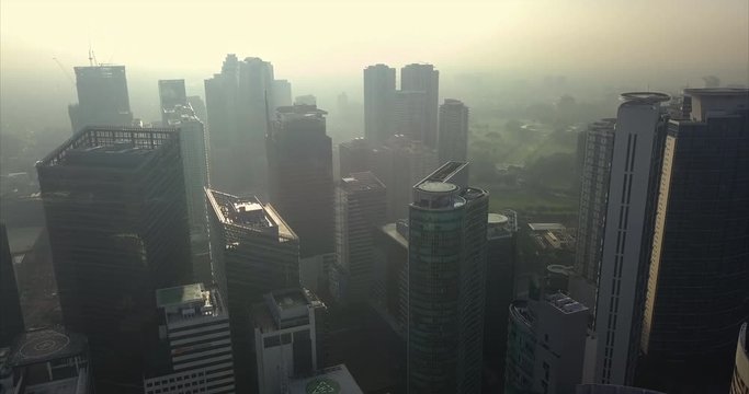 Straight aerial flight from helipad towards high rise buildings in metropolitan city. Drone, 4K.