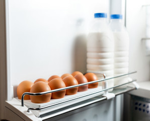 Milk and eggs in the door fridge. Organic Chicken Eggs Keep Fresh In The Fridge. Brown eggs in the tray. Organic Chicken Eggs Keep Fresh In The Fridge. 