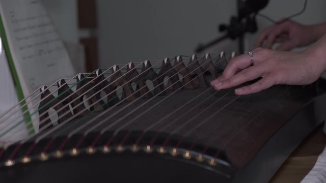Close up of playing Chinese music instrument Guzheng by online class at home amid coronavirus pandemic