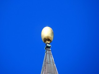 Golden sphere as lightning arrester with blue sky background and copy space