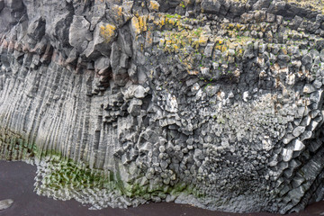 Basalt columns and textured volcanic rock seaside in West Iceland.