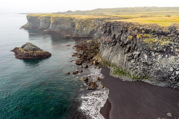 Basalt columns and textured volcanic rock seaside in West Iceland.