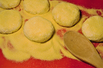 Billets of home cheesecakes on red culinary latex. And a wooden spoon