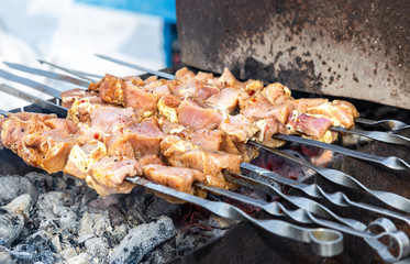 Grilled appetizing kebab cooking on metal skewers