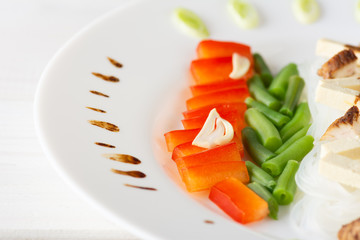 Glass noodle of funchosa with chicken and vegetables on a white background. Closeup.