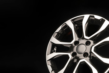 stylish alloy wheels, black with silver and polished on a dark background. copyspace