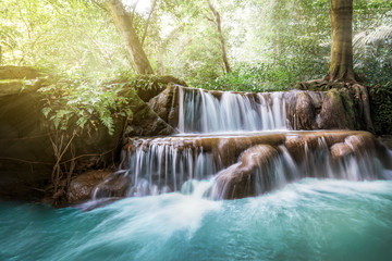 Waterfall and cascades in the jungle forest in Thailand. beautiful forest landscape, trees water and sun