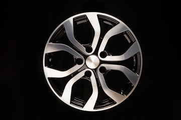 New car alloy wheel, close-up on a black background