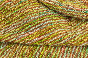 knitted fabric background with garter stitch pattern in green and brown