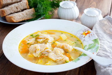 Homemade chicken soup with dumplings in a white plate, selective focus