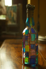 Szklana butelka pomalowana na różne kolory - obrazy, fototapety, plakaty