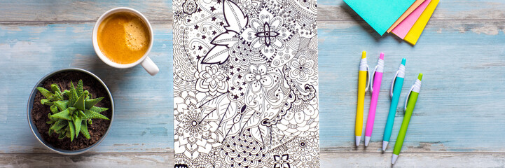 Adult coloring book, stress relieving trend. Art therapy, mental health, creativity and mindfulness concept. Flat lay web banner, panoramic close up shot.