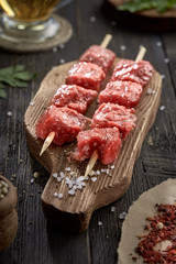 Fresh raw beef on skewers on a wooden cutting Board. Raw kebab.