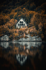 A house cabin on the lake Bohinj in autumn vibes with reflections and trees