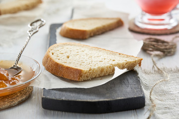 Breakfast with bread on the cutting Board and fruit jam on wooden table.
