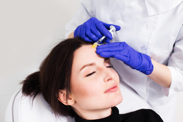 A woman on the procedure of injections in a cosmetology clinic