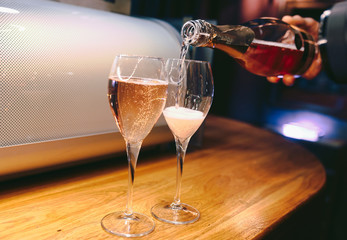 Bartender pouring champagne into glass, close-up