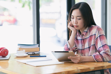 Young asian woman hand hold digital tablet. Asia women using tablet tablet computer in coffee shop.