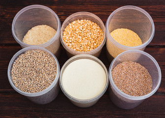Raw porridge, food supplies in the kitchen. A variety of cereals in the food containers.