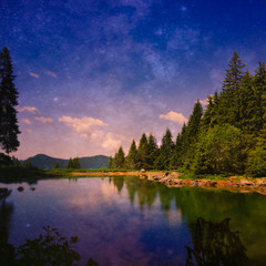 Fototapeta premium Beautiful night/morning sky reflecting on a mountain lake