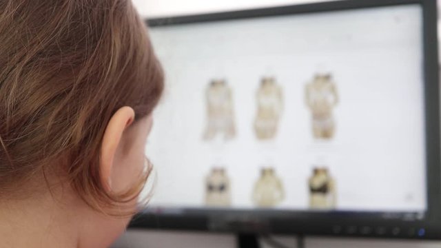 girl looks at the goods in the online clothing store. people use a computer, online shopping. Girl is choosing a lingerie . Close up.