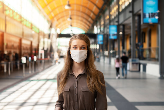 Woman wearing white protective face mask is using public transportation during the epidemic outbreak