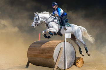 Eventing: equestrian rider jumping over an obstacle