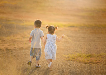 Naklejka na ściany i meble happy child boy and girl overall playing on sunny field, summer outdoor lifestyle, cozy mood