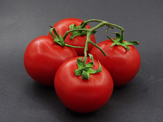Organic garden tomatoes on green leaves                              
