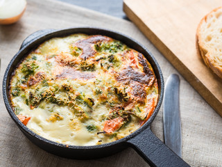Italian omelet, frittata with broccoli in a cast-iron pan, top view, close-up - breakfast at home