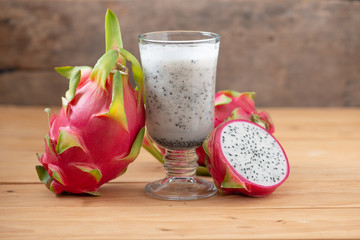 Dragon fruit smoothie on wooden table.