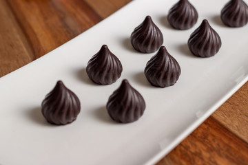 drop-shaped chocolates in a white plate