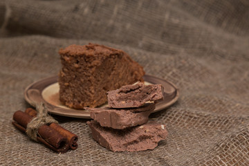 Fresh brownies decorated with orange peel on wooden board, space for text. Delicious chocolate pie.