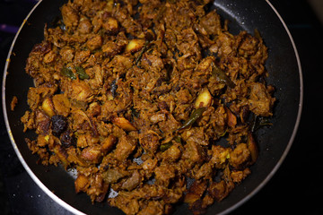 South Indian dish spicy beef fry Kerala, India. side dish ghee rice, appam, parotta, puttu, bread and chappathi, Kerala cuisine ,Buffalo roast / Meat pepper fry with coconut. India spices cooking,
