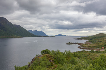 Norwegian fjord and mountains surrounded by clouds, ideal fjord reflection in clear water. selective focus.