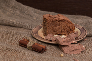 Fresh brownies decorated with orange peel on wooden board, space for text. Delicious chocolate pie.