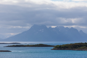 Obraz premium Norwegian fjord and mountains surrounded by clouds, ideal fjord reflection in clear water. selective focus.