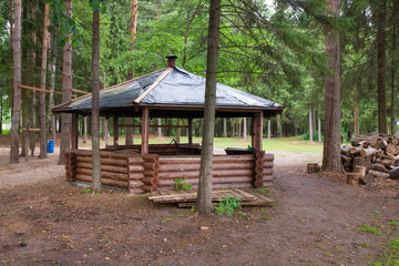 Beautiful gazebo in the woods next to the lake on an autumn day