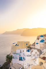 Sunset view of Oia  with blue domes,  Thirasia in the back, Santorini island, Cyclades, Greece