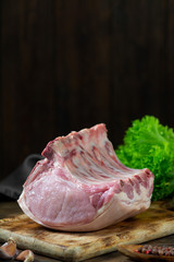 Raw pork ribs on a wooden Board on a wooden background. Raw pork meat. Rustic style. With space for text