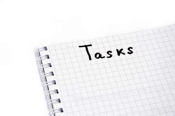 Notebook with a spiral in a cage on a white background. Above in a notebook is written tasks with a black marker, pen. Notepad top view. Notepad  Part