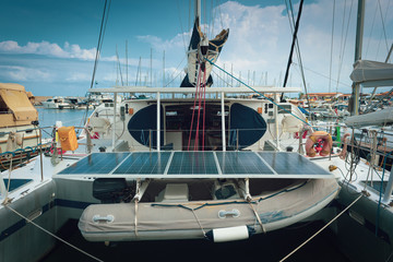 Yacht equipped with electric solar panels. Outdoors sea port view.