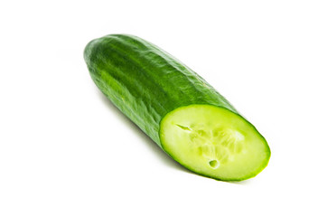 One greenhouse cucumber on a white background is cut at an acute angle. Fresh cut cucumber. Cucumber in macro visible  inside